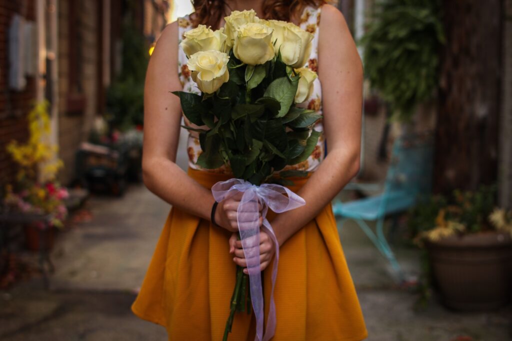 kobieta trzyma bukiet białych róż
