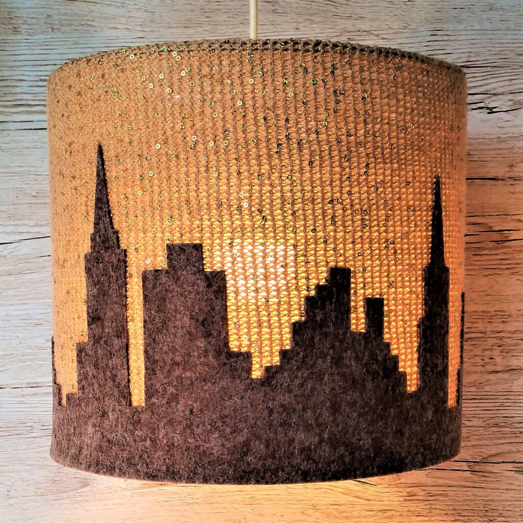złoto-brązowa lampa sufitowa z motywem miasta